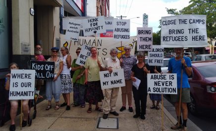 About 20 members of the Lismore Group holding placards standing outside their MP's office calling for the closure of Manus and Nauru