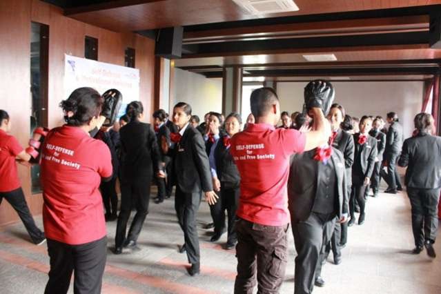 A room of people practicing self-defence.