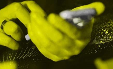 Yellow hands hold a mobile phone.
