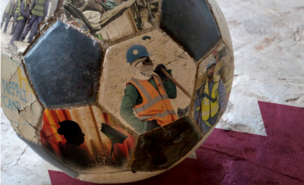 A soccer ball with images of migrant workers on the Qatar flag