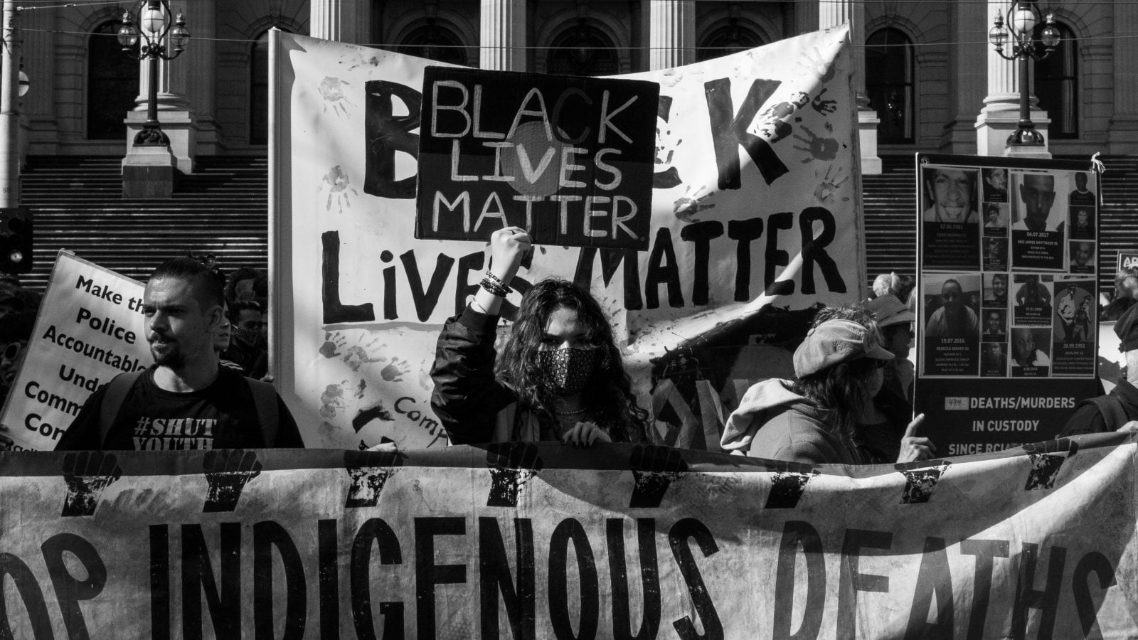 A group of protestors waving Black Lives Matter banners at the Black Deaths in Custody Rally in Melbourne, 2021.