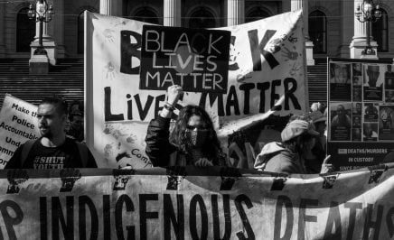 A group of protestors waving Black Lives Matter banners at the Black Deaths in Custody Rally in Melbourne, 2021.