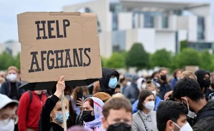 A participant holds up a placard reading 'Help Afghans' during a demonstration