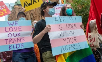 Protesters hold signs at a rally in Sydney that read 