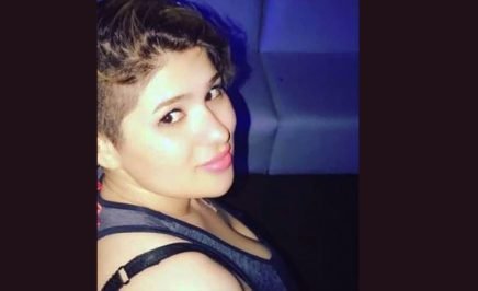 Zahra Sedighi-Hamadani glances at the camera side on. She has short hair, pink lips and is wearing a grey singlet.