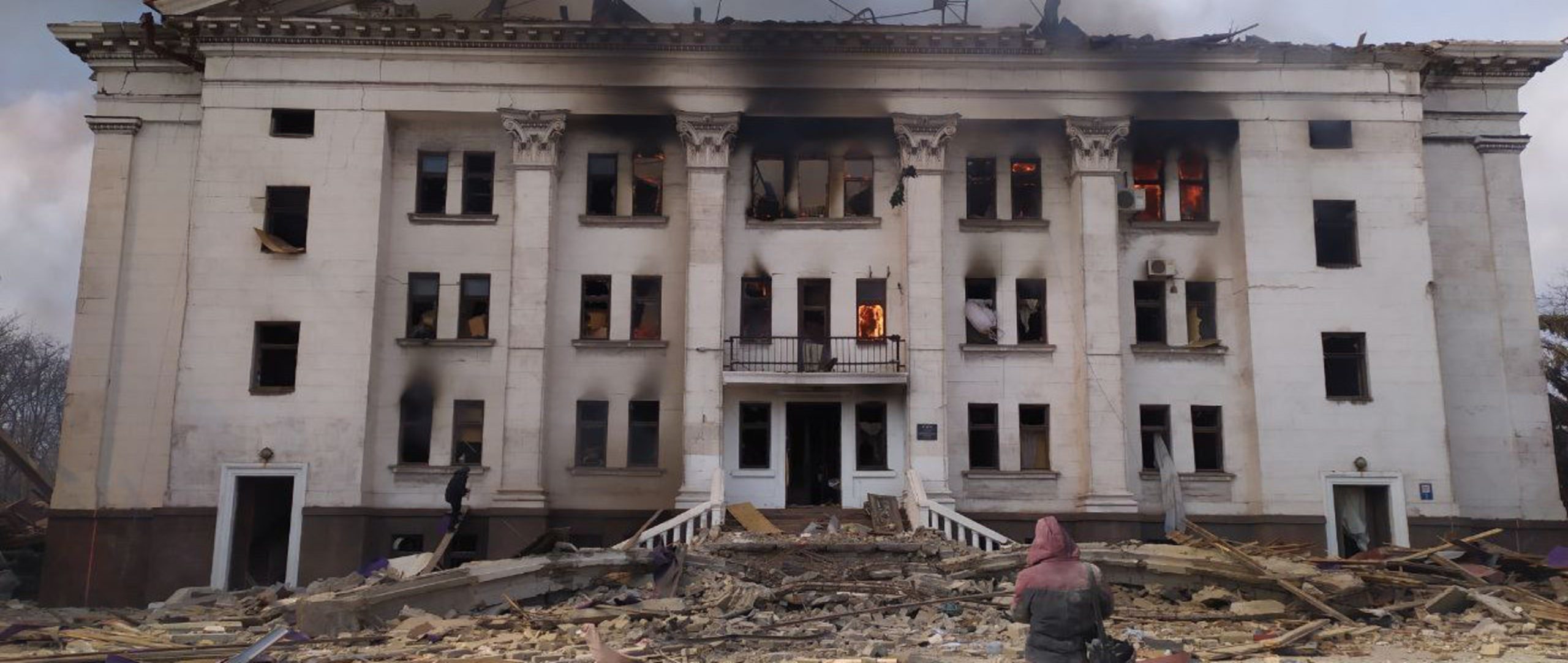 An actor who used to perform at the theatre and a survivor of the attack, stands outside the rear of the Mariupol theatre in Ukraine moments after the explosion.