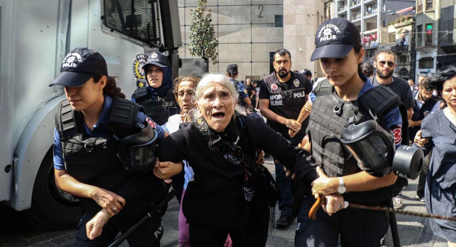 Elderly woman being detailed by female police at demonstration